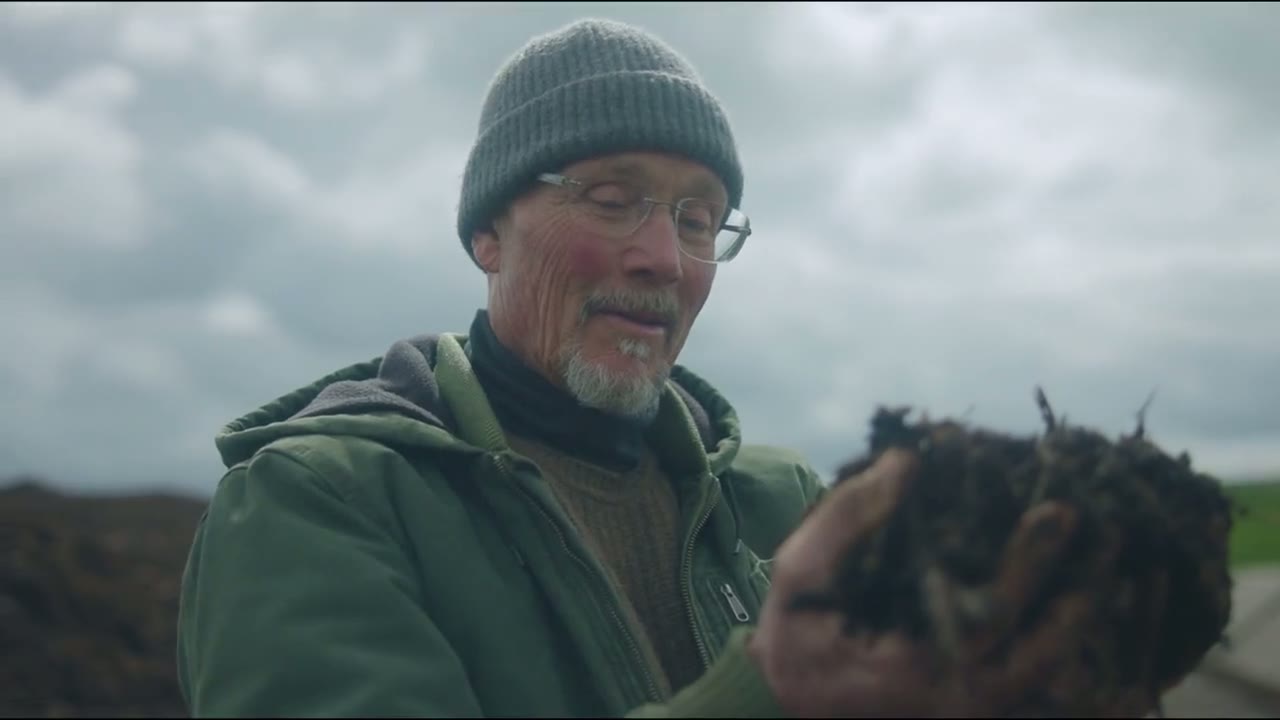 Un agricultor enseña compost en sus manos